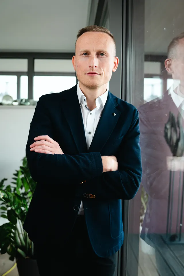 Eric Zentgraf, Geschäftsführer von Praxishelden, mit verschränkten Armen am Fenster